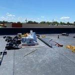 picture of buckets, tarps and other materials on gray flat roof ready to use