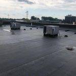 wide view of new gray flat roof with three A/C units on it