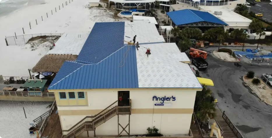 aerial shot of Angler's restaurant roof half-finished on a winter day with men installing roofing material